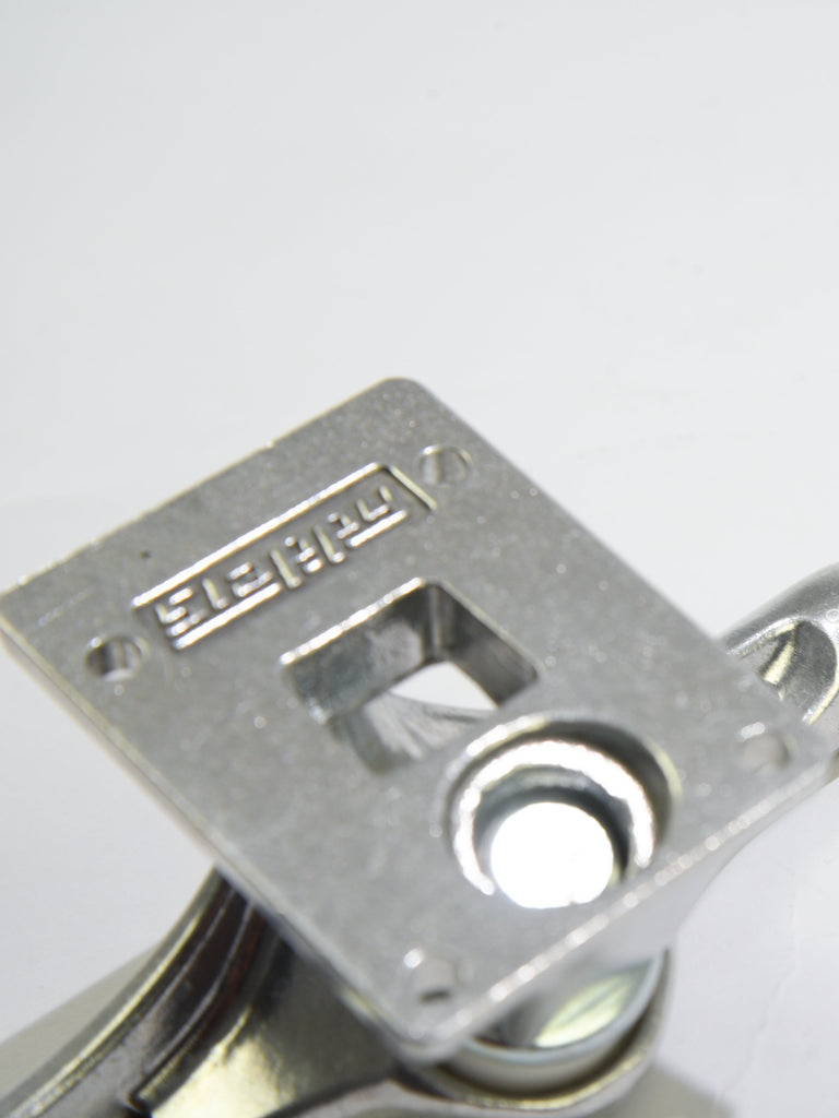 Metal latch or lock mechanism with a square plate and circular opening.