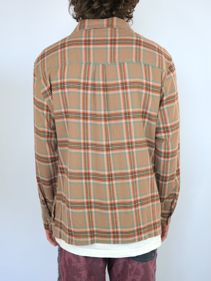 Plaid flannel shirt with a tan base color and red and green stripes.