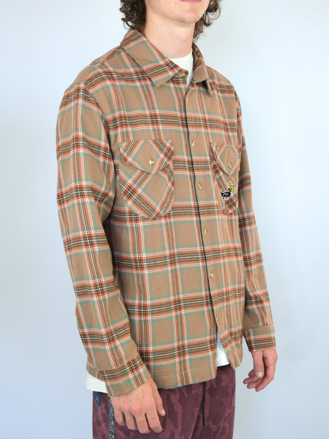 Plaid flannel shirt with a tan base color and red and green stripes.