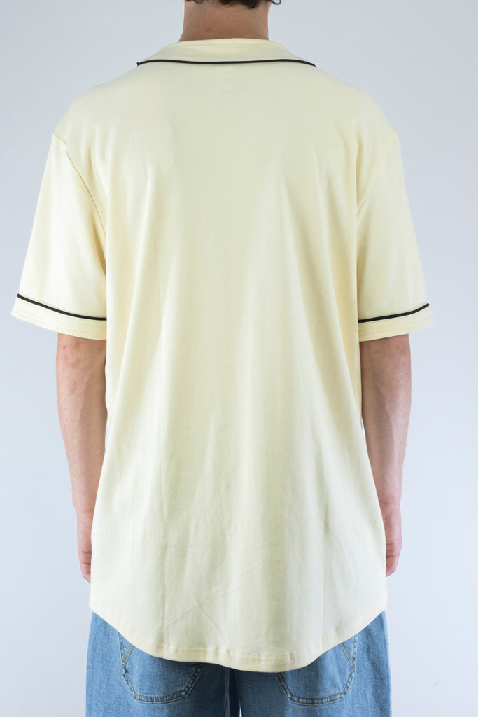 Pale yellow polo shirt with dark trim on the collar and sleeves.