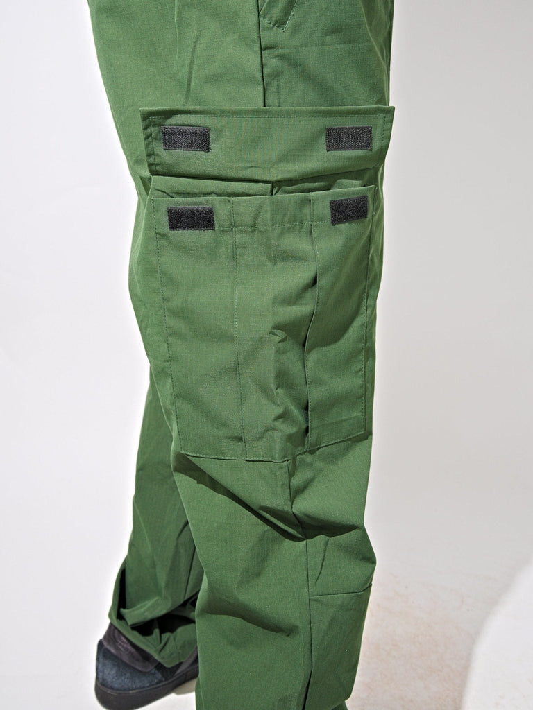 Green cargo pants with multiple pockets and Velcro patches from Snack Skateboards Mantis