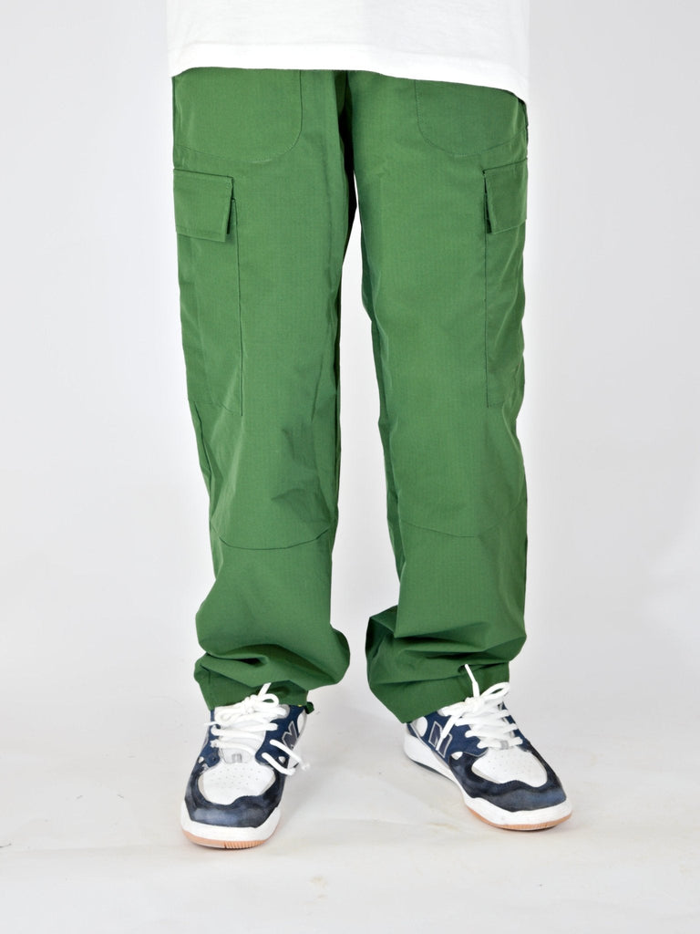 Green Ninja Cargo Pants with side pockets styled over blue and white sneakers