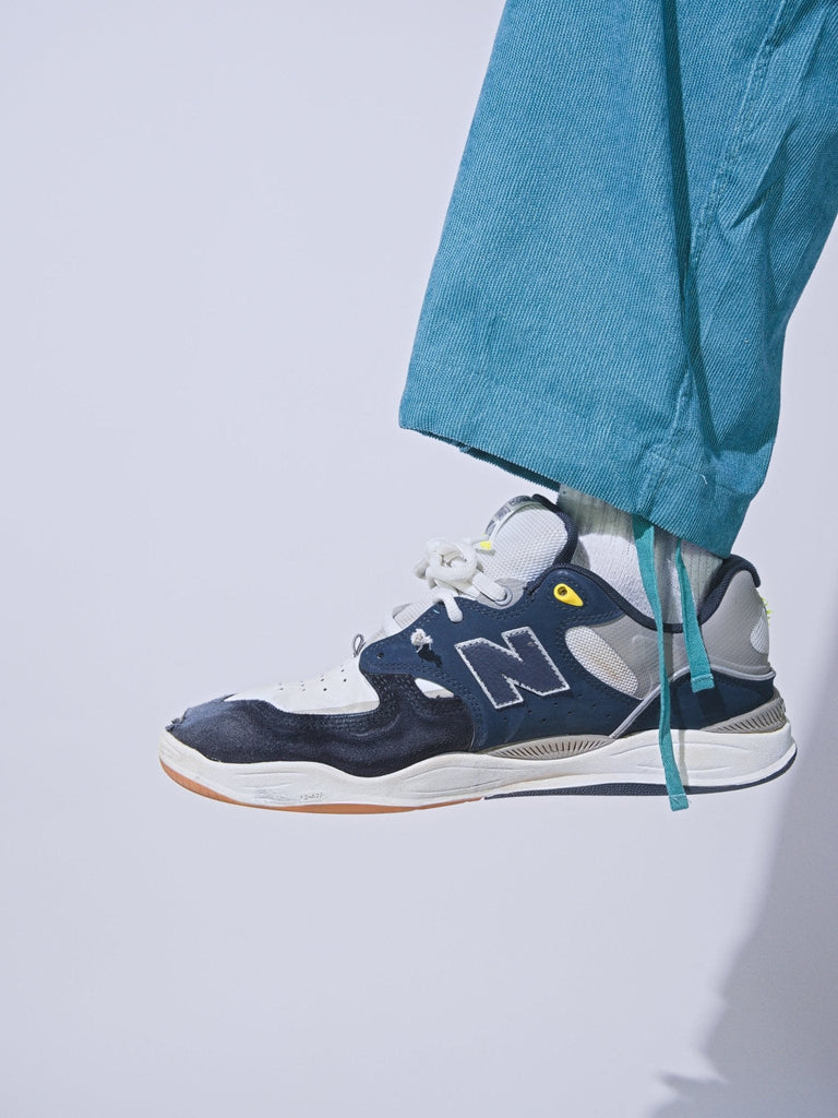 New Balance sneaker in navy, white, and gray paired with Snack Skateboards Coduroy Cargo Pants