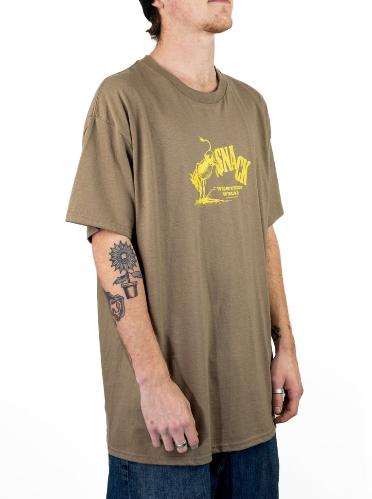 Tan Snack Skateboards Western Wear tee featuring a yellow Chin Up graphic design