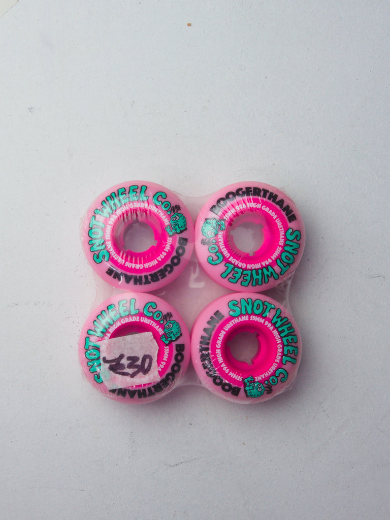 Four pink and turquoise skateboard wheels arranged in a square pattern.