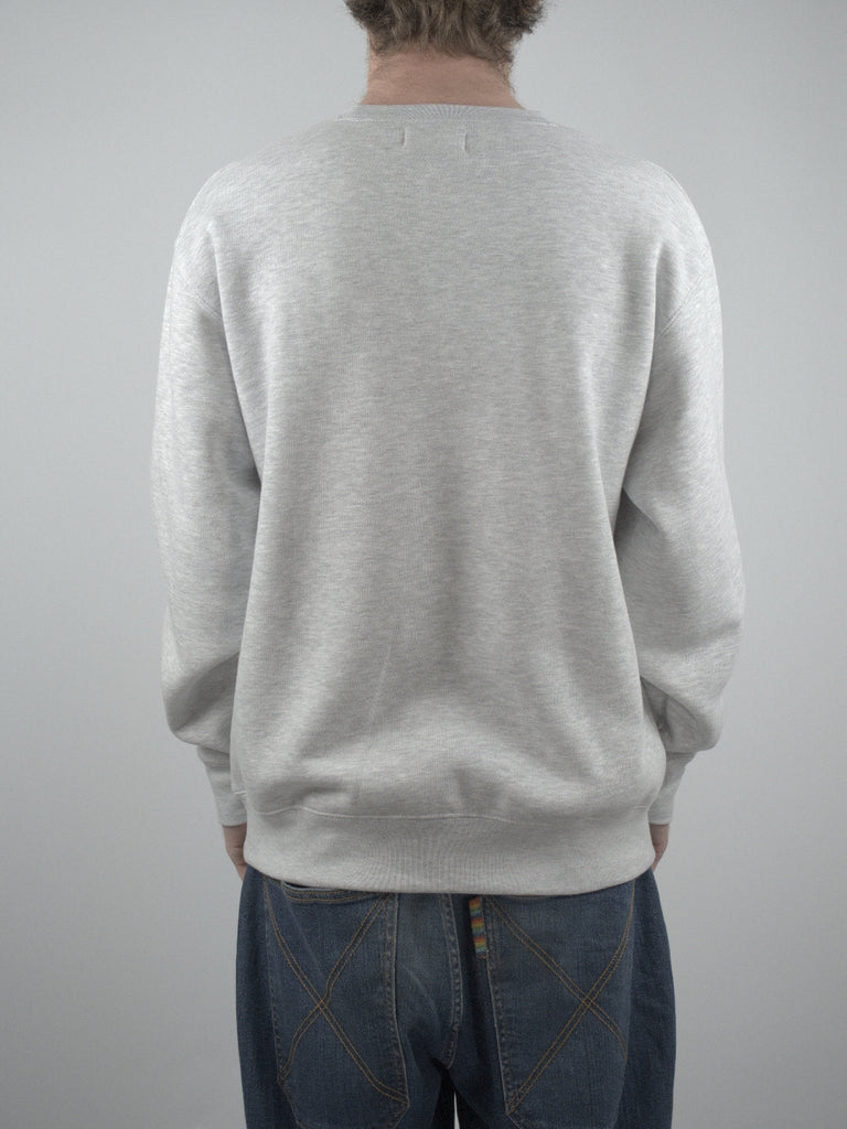 Light gray crewneck sweatshirt worn by a person facing away from the camera.