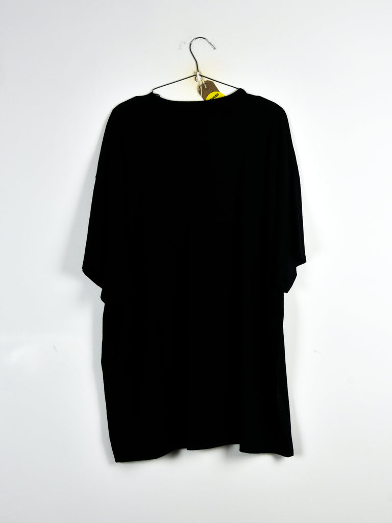 Black t-shirt hanging on a wire hanger.
