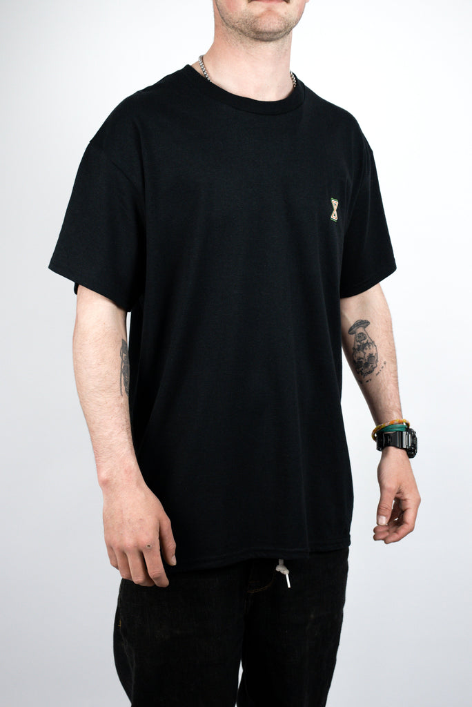 Black t-shirt with a small gold emblem on the chest.