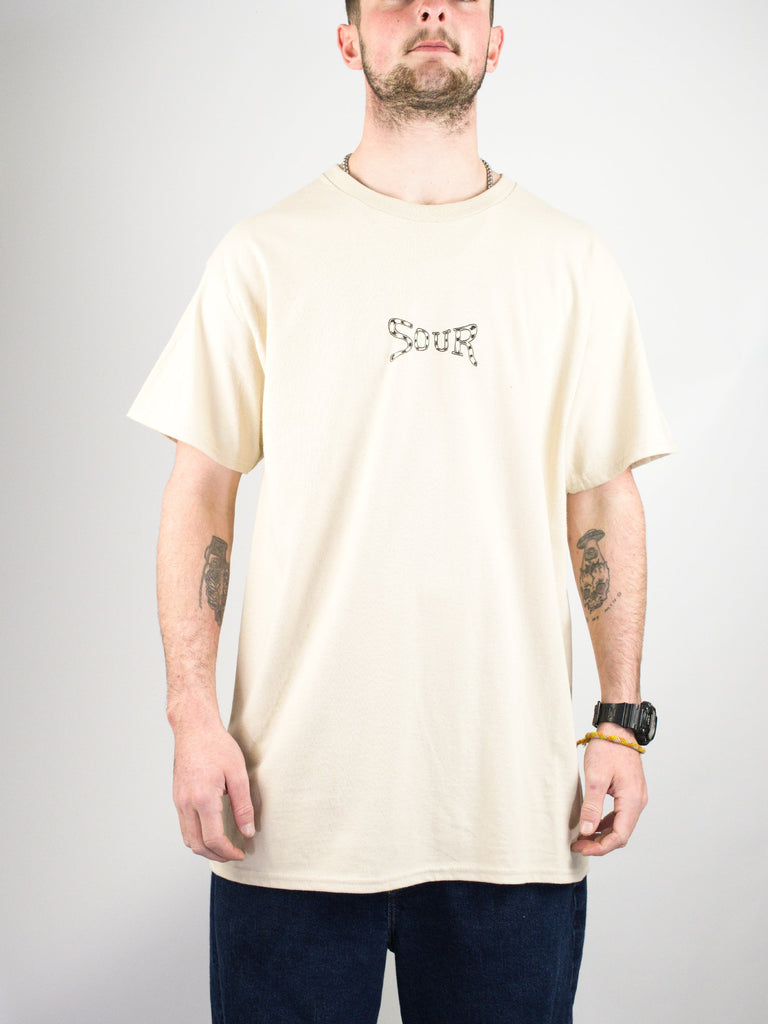 Cream-colored t-shirt with a small graphic design on the chest.