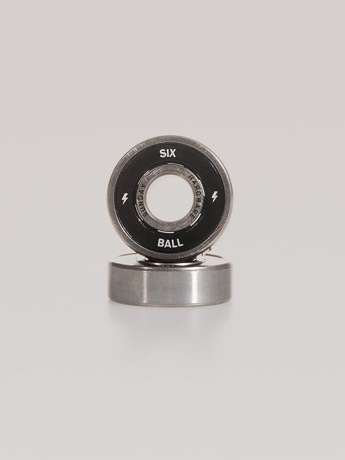 Circular metal bearing labeled ’SIX BALL’ with lightning bolt symbols.