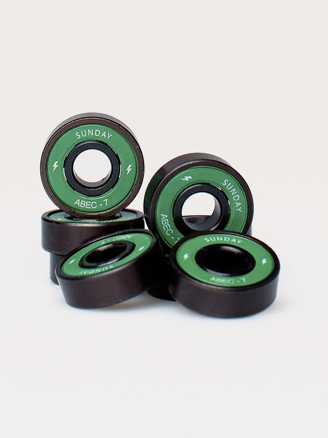 Skateboard bearings with green and black coloring labeled ’Sunday’ and ’ABEC-1’’.