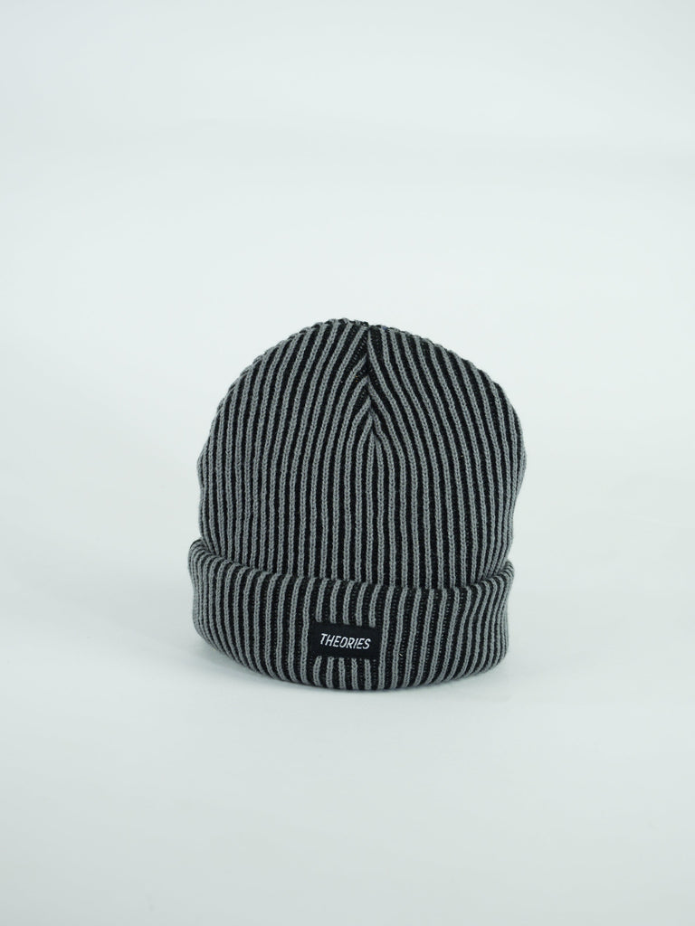 Striped gray and black knit winter beanie with a small label.