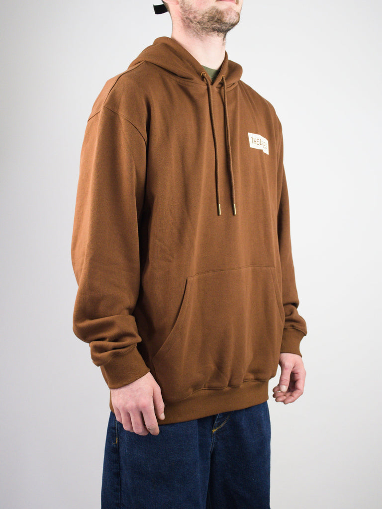 Brown hooded sweatshirt with a front pocket and small white logo patch.