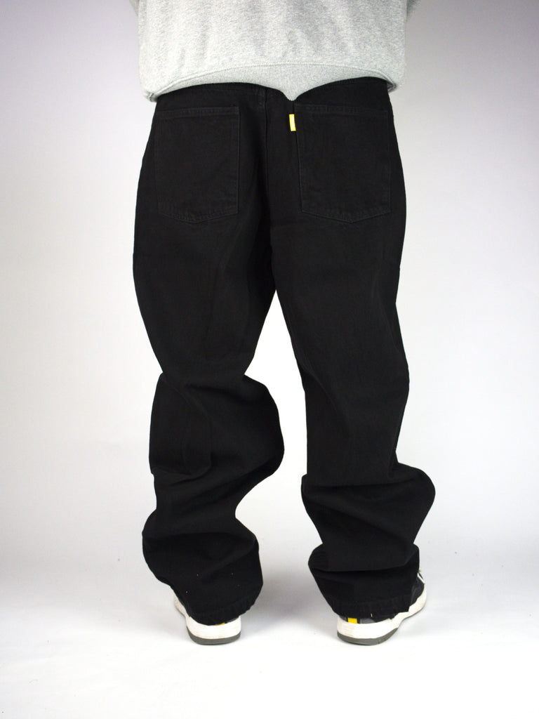 Pair of black baggy pants or trousers with a zipper fly.