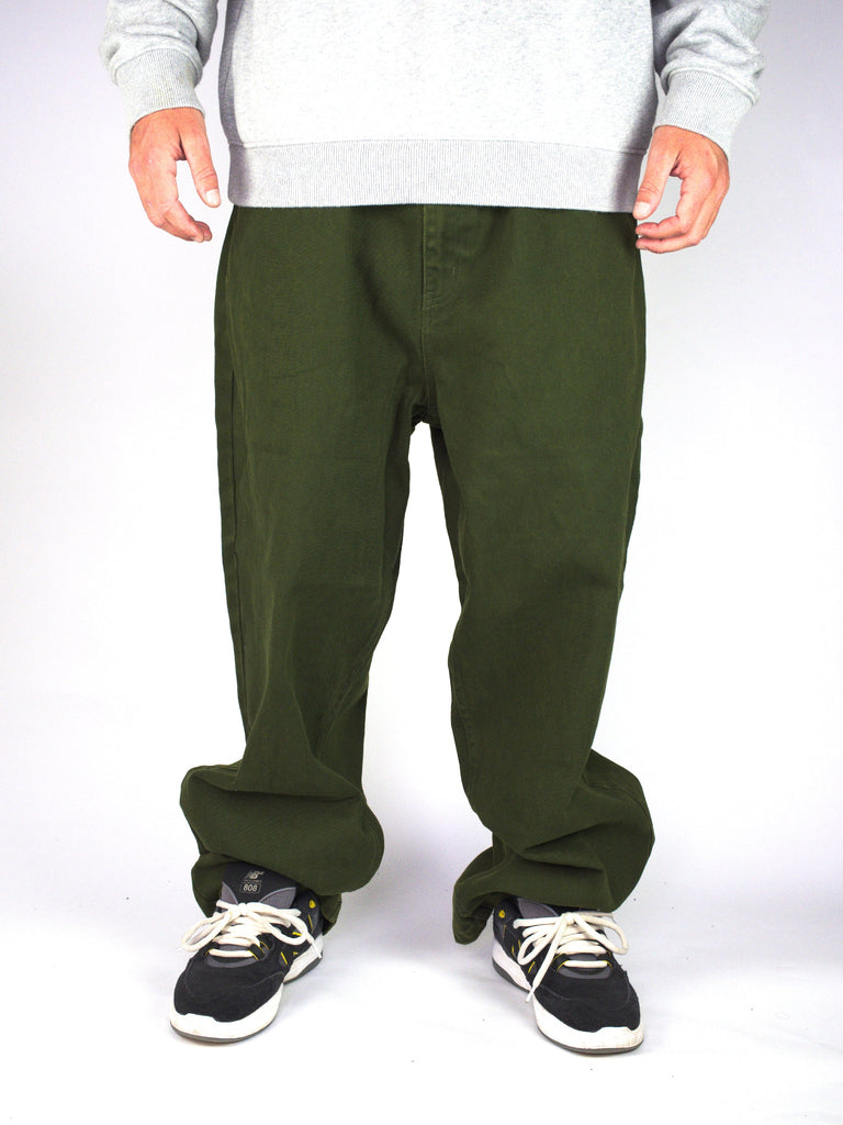 Olive green baggy Plaza Denims paired with black and white sneakers for a stylish look