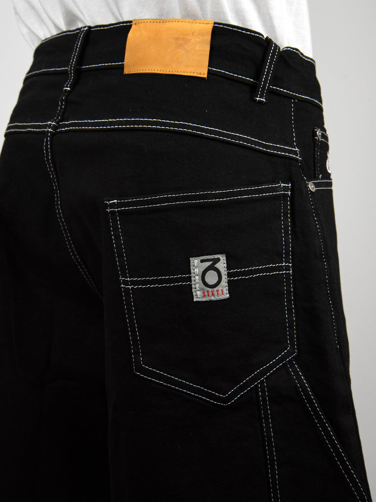 Black denim jeans with contrasting white stitching and a distinctive brand patch on the back pocket.