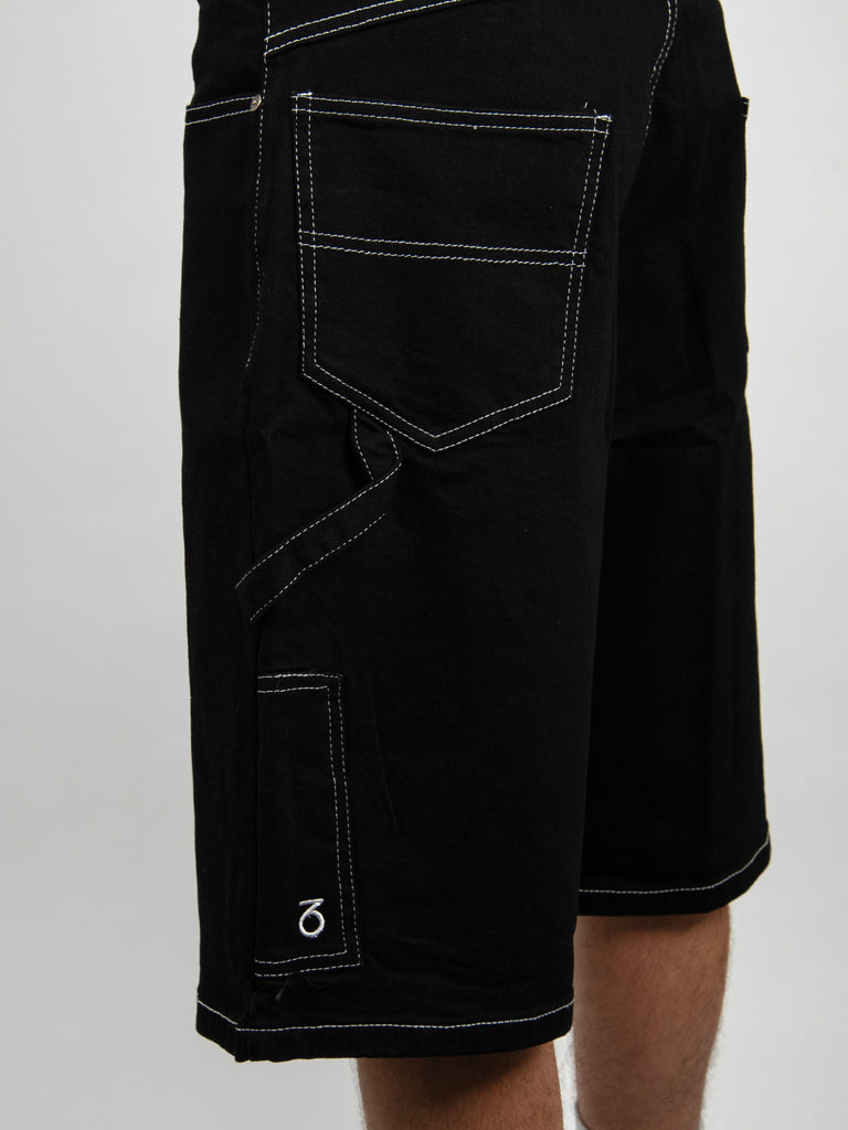 Black denim shorts with contrasting white stitching and multiple pockets.