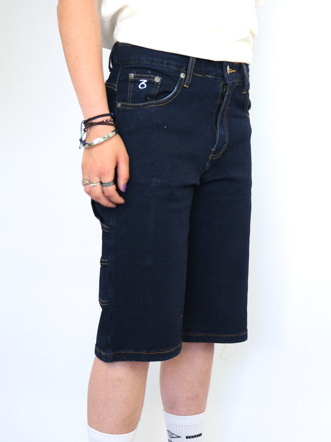 Dark blue denim knee-length shorts with visible pockets and stitching.