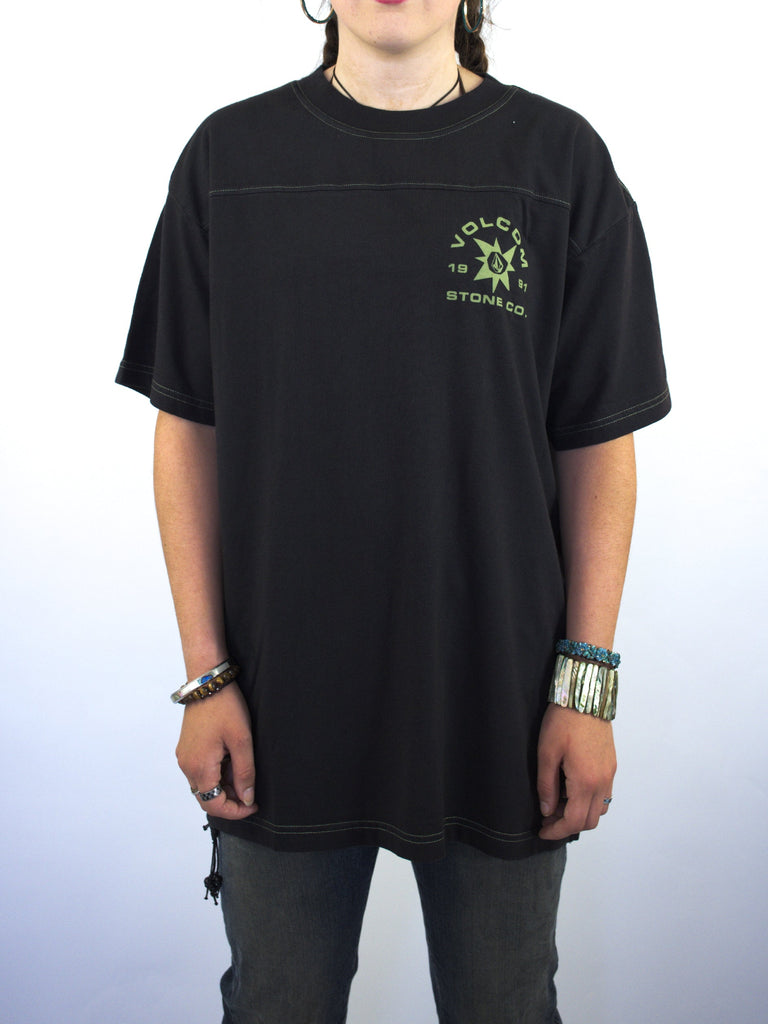 Black t-shirt with a small green graphic design on the chest.