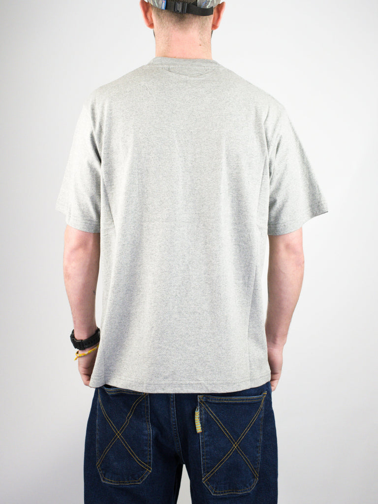 Back view of a person wearing a plain gray t-shirt and blue jeans.