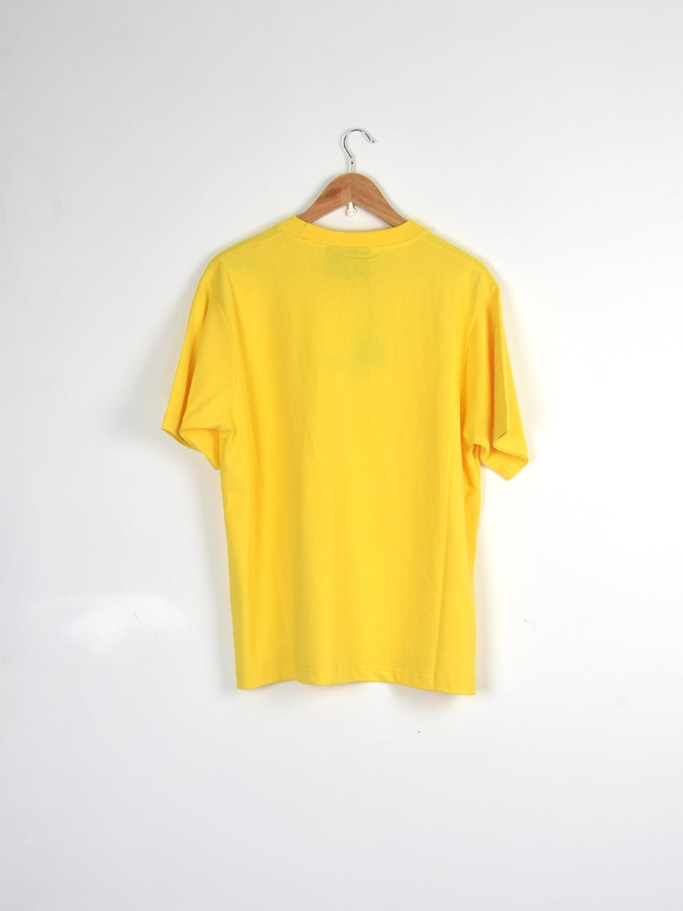 Bright yellow t-shirt hanging on a wooden hanger.
