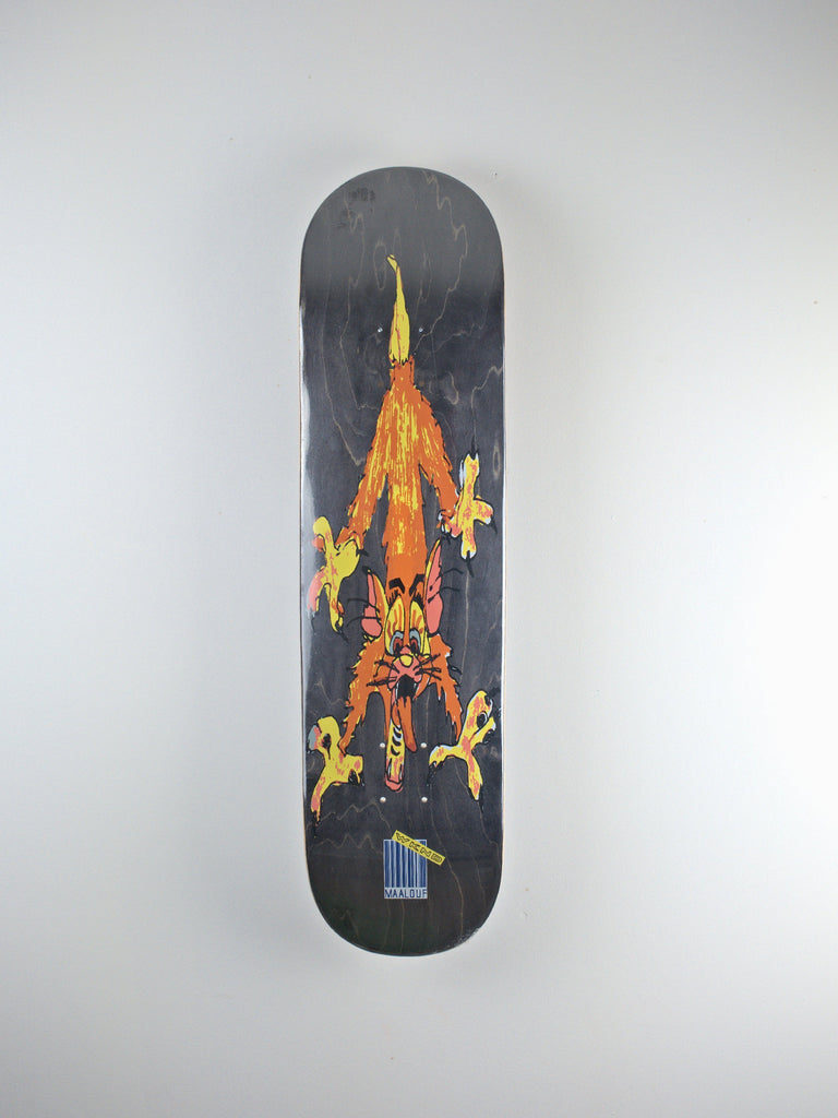 Skateboard deck featuring a colorful, stylized cat-like creature design on a dark background.