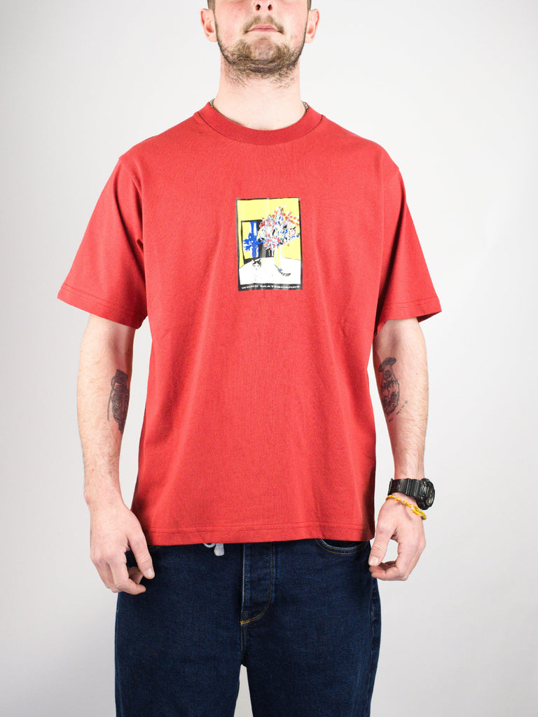 Red t-shirt with a small rectangular graphic design on the front.