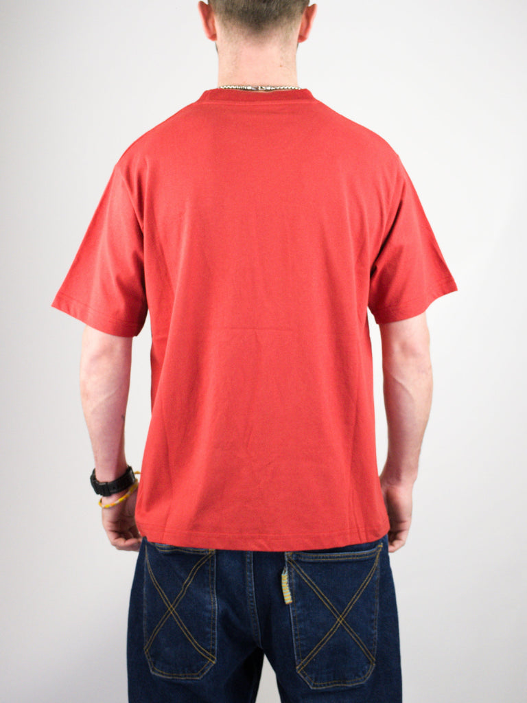 Red t-shirt worn with dark blue jeans.