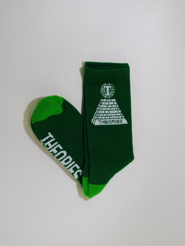 Green sock with a pyramid and eye design and ’Theories’ text on the sole.